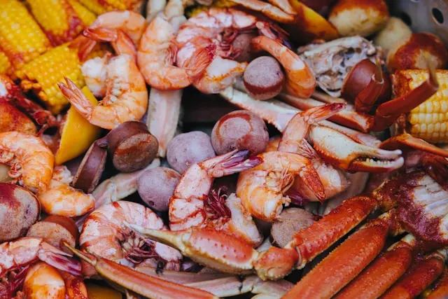 Example of cajun food including boiled shripm, potato, corn, and crab.